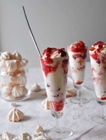 Eton mess dessert with strawberries and meringue in a tall glass