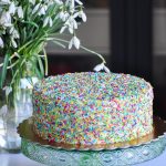 Funfetti birthday vanilla cake on a cake stand and a cut piece of cake