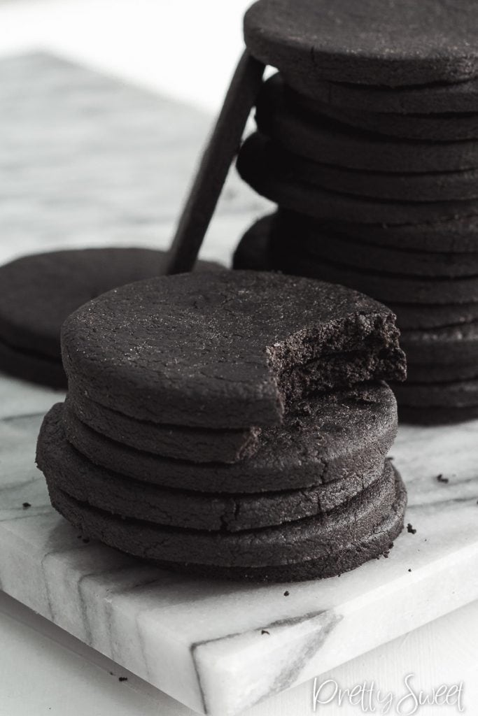 dark cocoa sable cookies in a stack with a bite