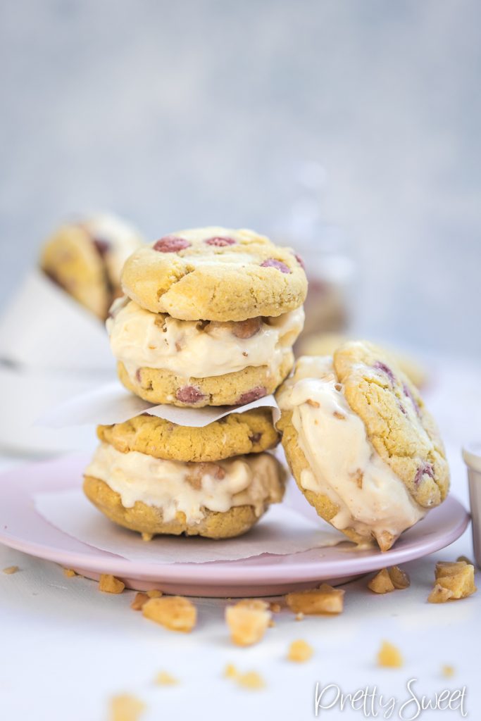 Three home-made ice cream chocolate chip sandwiches stacked on a pink plate