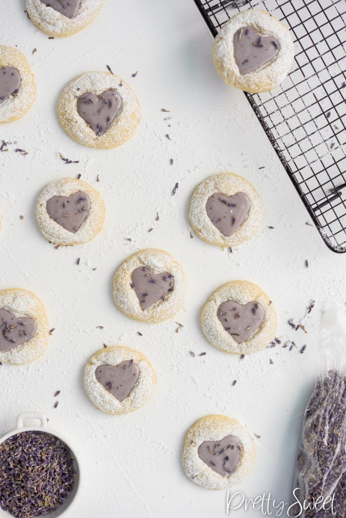 Lemon cookies with lavender icing with a heart stamp on a white board