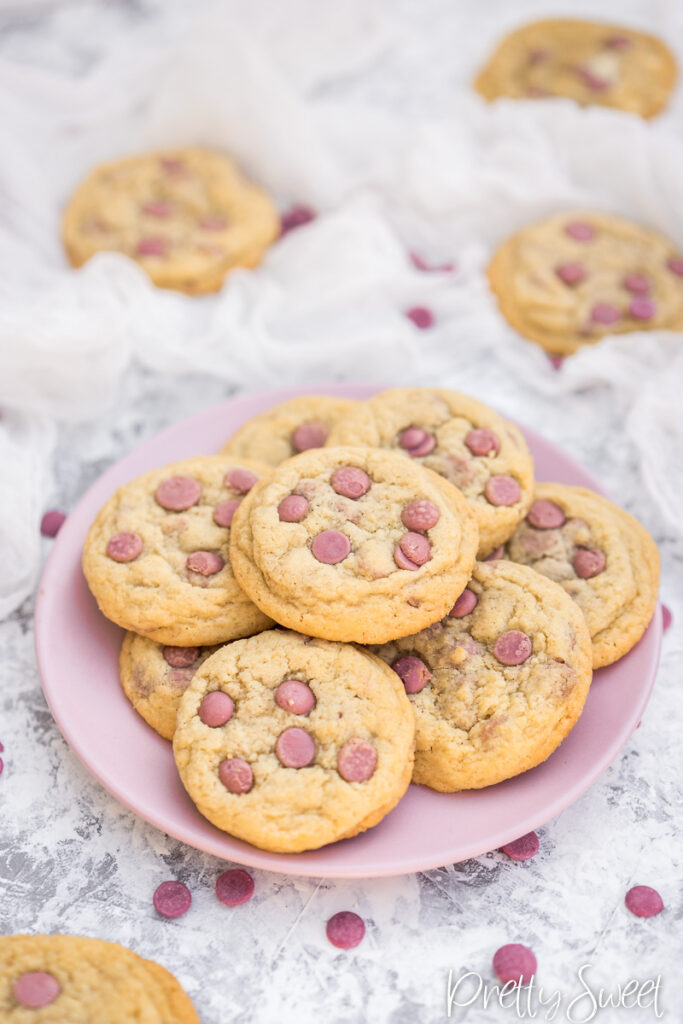 Ruby chocolate chip cookies piled on a pink plate