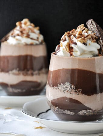 two chocolate hazelnut desserts in a glass with whiped cream on top