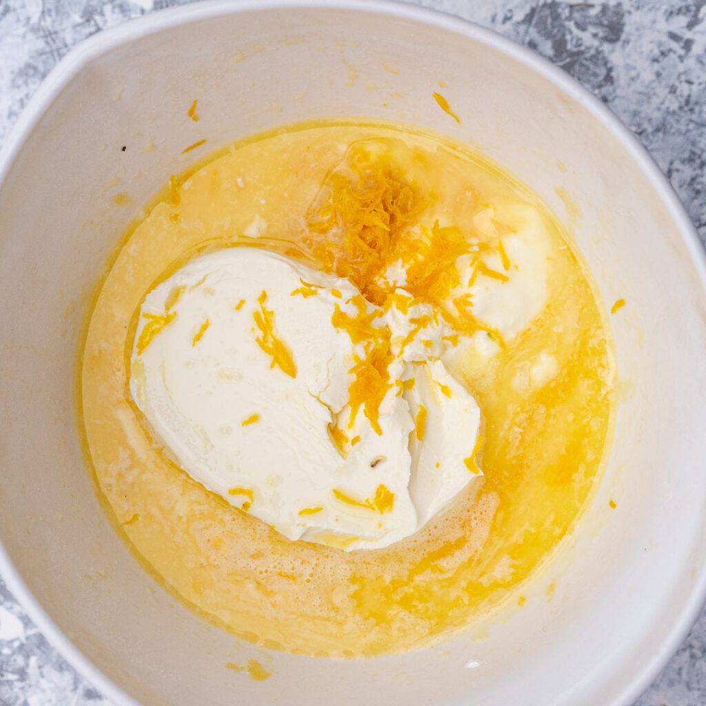 cream cheese, lemon zest and juice with egg mixture in a white bowl